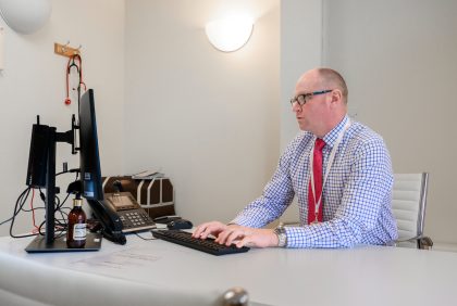 A consultant takes notes on a computer