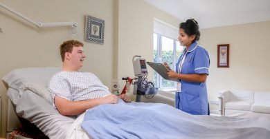 A nurse talks with a patient in their private room