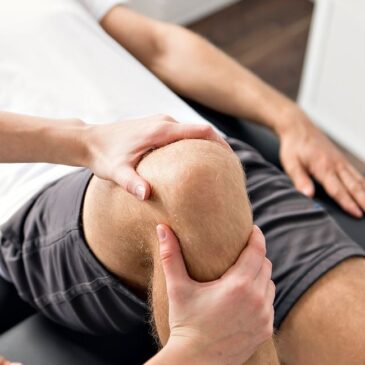 Physiotherapist massaging patients knee to loosen joint