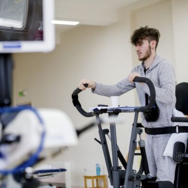 Patient on standing exercise machine