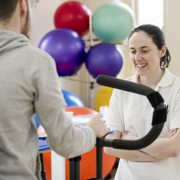 Physio supporting patient during exercise