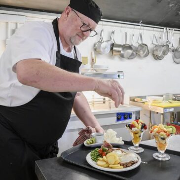 Chef preparing trayed meal in kitchen