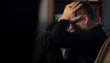 man looking depressed with hands on head